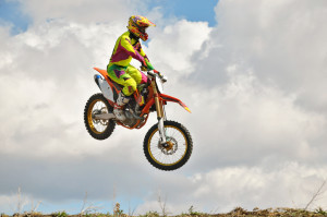 Motocross rider on a motorcycle is flying spectacularly in the last part of the flight